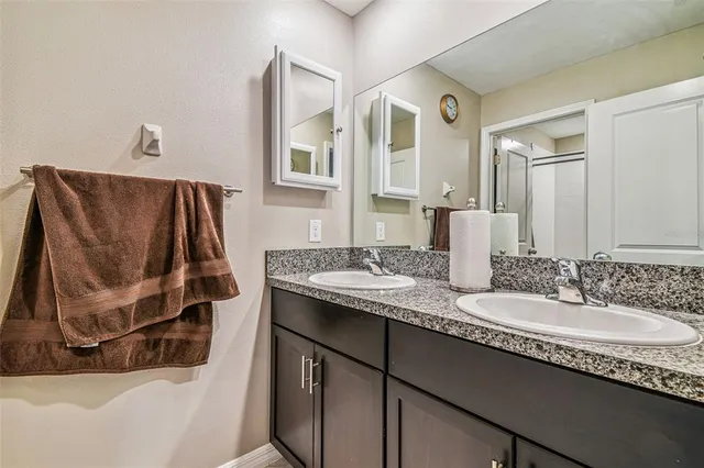 a bathroom with a granite countertop sink and a mirror