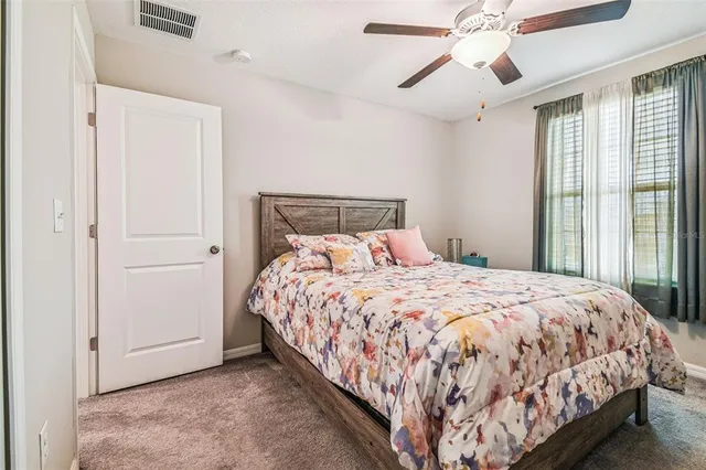 a bedroom with a bed and large windows