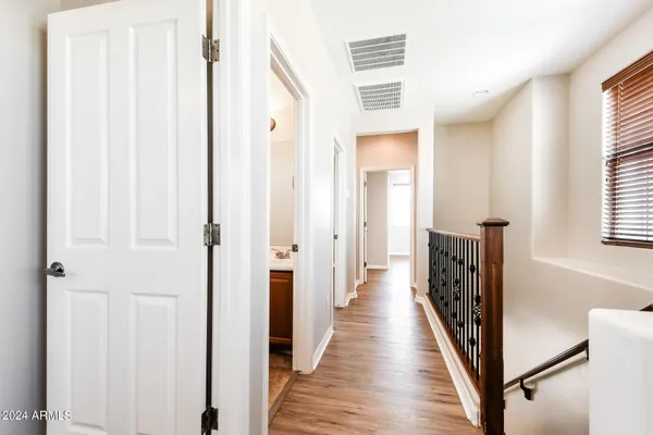 a view of a hallway with wooden floor and windows