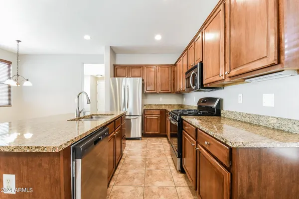 a kitchen with stainless steel appliances granite countertop a sink stove and refrigerator
