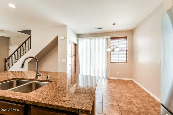 a kitchen with granite countertop a sink and a refrigerator