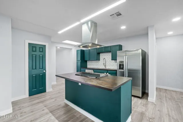 a kitchen with stainless steel appliances granite countertop a refrigerator a sink and a stove