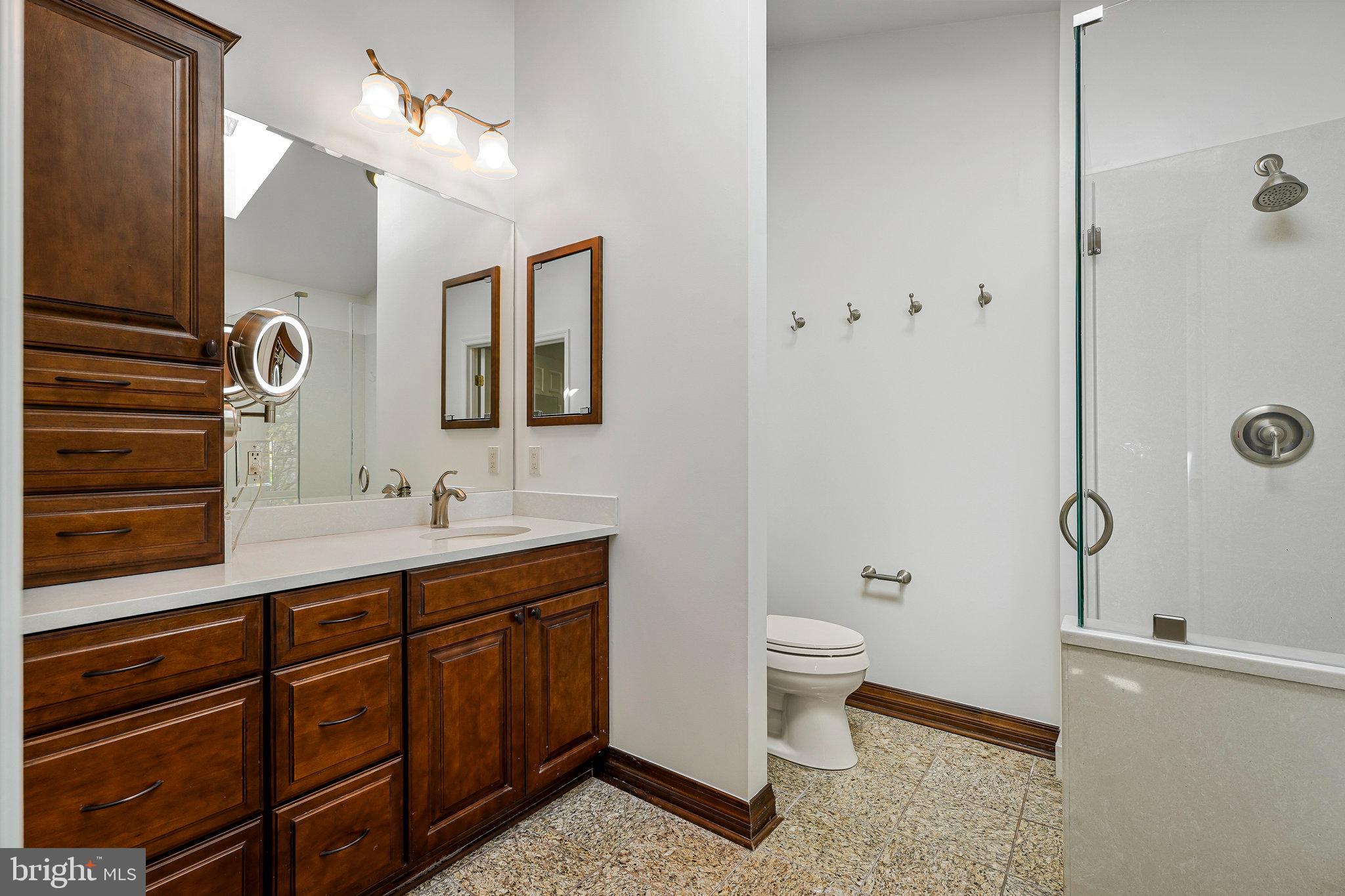 6556 Antrican Drive Springfield, VA 22150 - Photo 23 of 36 a bathroom with a double vanity sink toilet and mirror