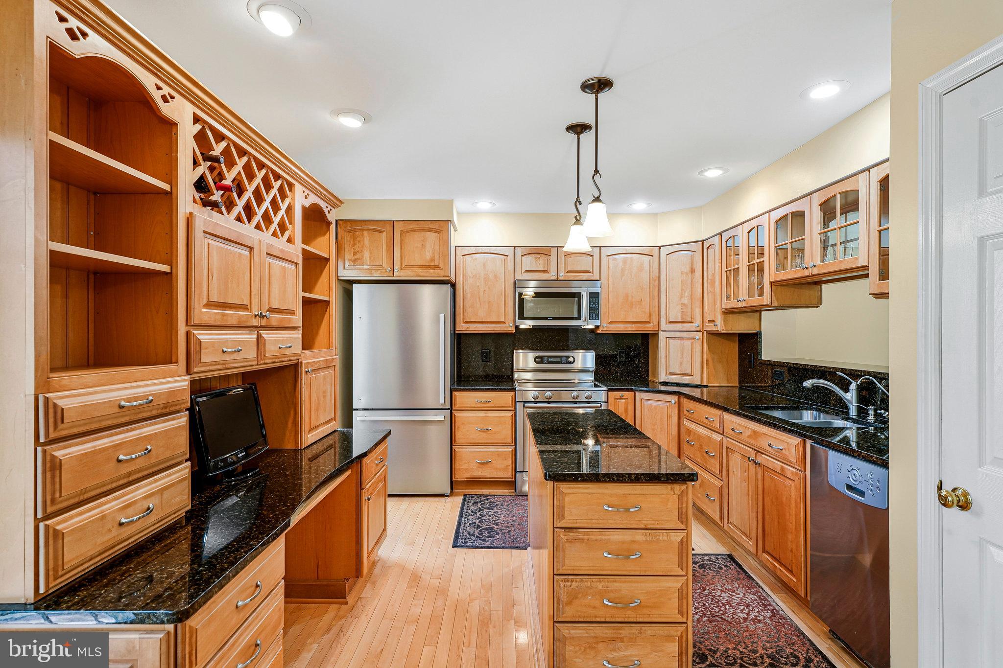 6556 Antrican Drive Springfield, VA 22150 - Photo 10 of 36 a kitchen with stainless steel appliances granite countertop a refrigerator and a stove top oven
