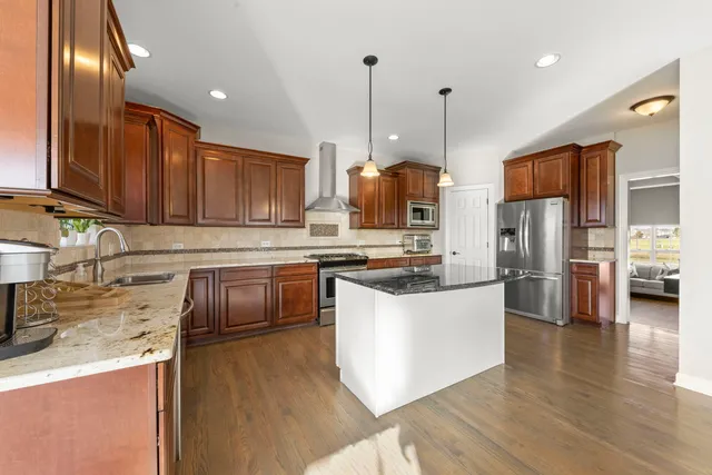 a kitchen with stainless steel appliances granite countertop a sink a stove and a refrigerator