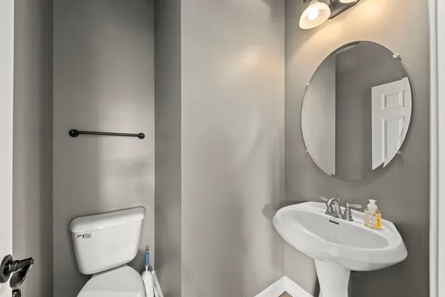 a bathroom with a toilet sink and mirror