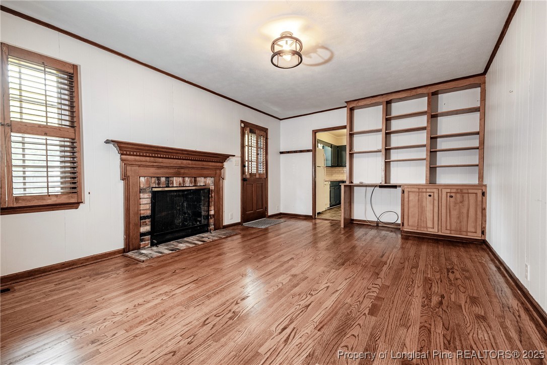 2818 Millbrook Road Fayetteville, NC 28303 - Photo 11 of 32 a view of empty room with wooden floor and fireplace