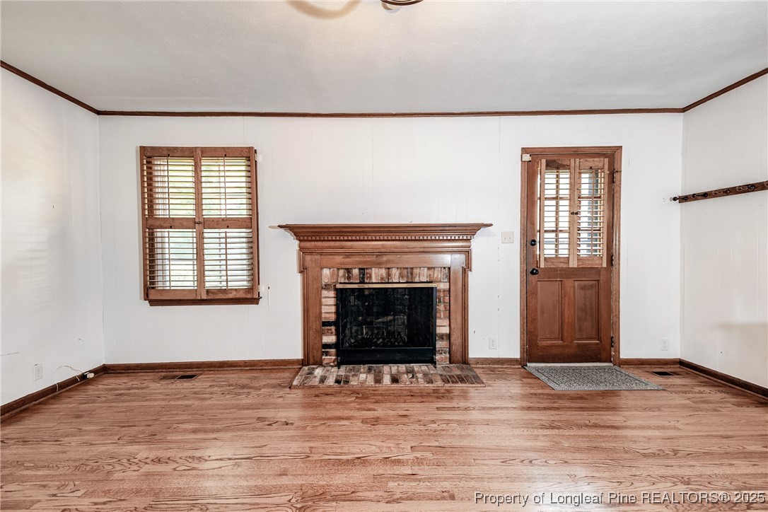 2818 Millbrook Road Fayetteville, NC 28303 - Photo 12 of 32 a view of an empty room with wooden floor and a window