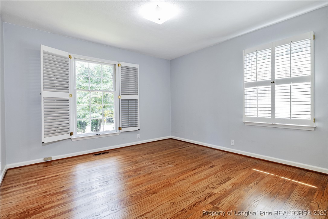 2818 Millbrook Road Fayetteville, NC 28303 - Photo 21 of 32 a view of an empty room with wooden floor and a window