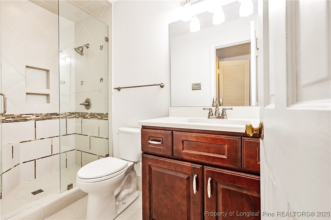 2818 Millbrook Road Fayetteville, NC 28303 - Photo 28 of 32 a bathroom with a sink a toilet and shower