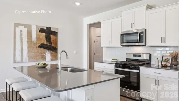 a kitchen with stainless steel appliances granite countertop a sink a stove and microwave