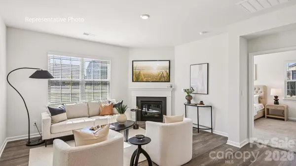 a living room with furniture a fireplace and a large window