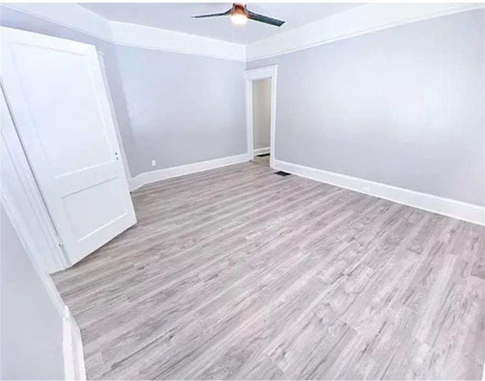1127 Metropolitan Parkway Southwest Atlanta, GA 30310 - Photo 13 of 23 an empty room with wooden floor and fan