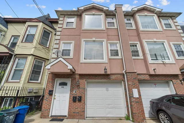 a front view of a residential apartment building with a yard