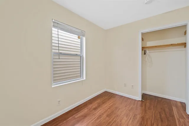 an empty room with wooden floor and a window