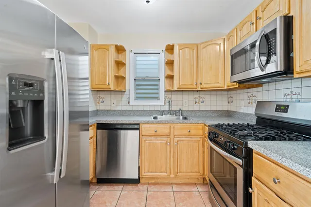 a kitchen with stainless steel appliances granite countertop a stove and cabinets