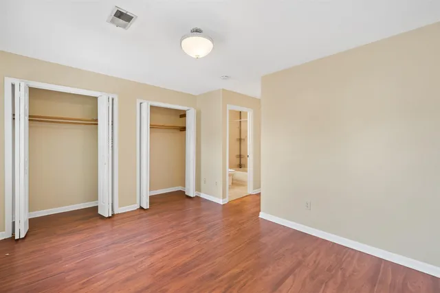 an empty room with wooden floor and closet