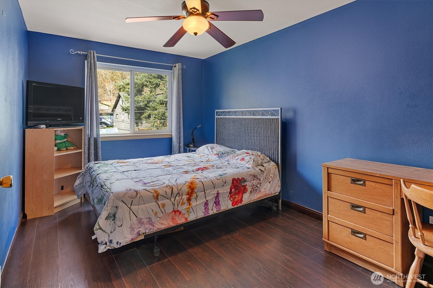 6352 24th Avenue Southwest Seattle, WA 98106 - Photo 15 of 31 a bedroom with a bed and a flat tv screen on dresser