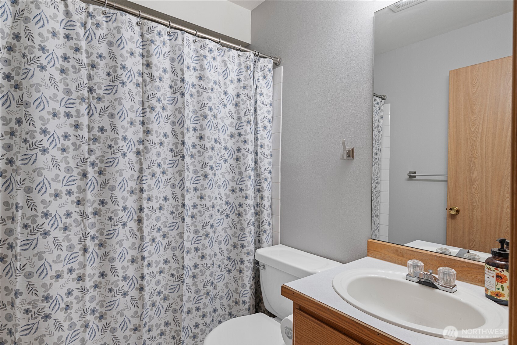 6352 24th Avenue Southwest Seattle, WA 98106 - Photo 19 of 31 a bathroom with a sink a toilet and shower curtain