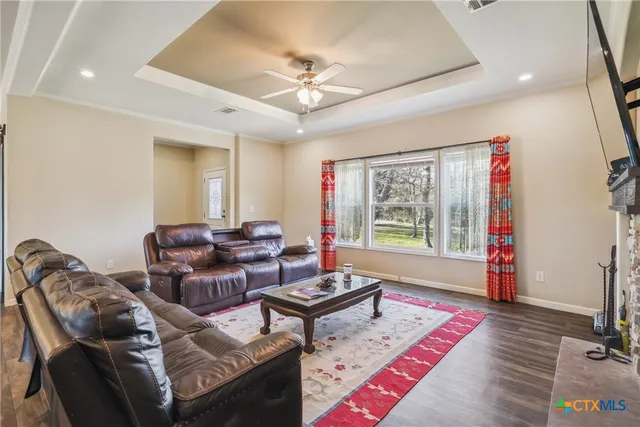 a kitchen with stainless steel appliances granite countertop a stove a sink dishwasher and a refrigerator with wooden floor