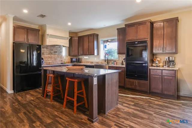 a kitchen with stainless steel appliances granite countertop a stove refrigerator sink and cabinets