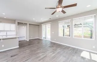 a view of an empty room with window and wooden floor