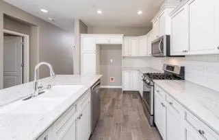a kitchen with a sink stove and cabinets
