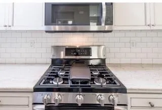 a stove top oven sitting inside of a kitchen
