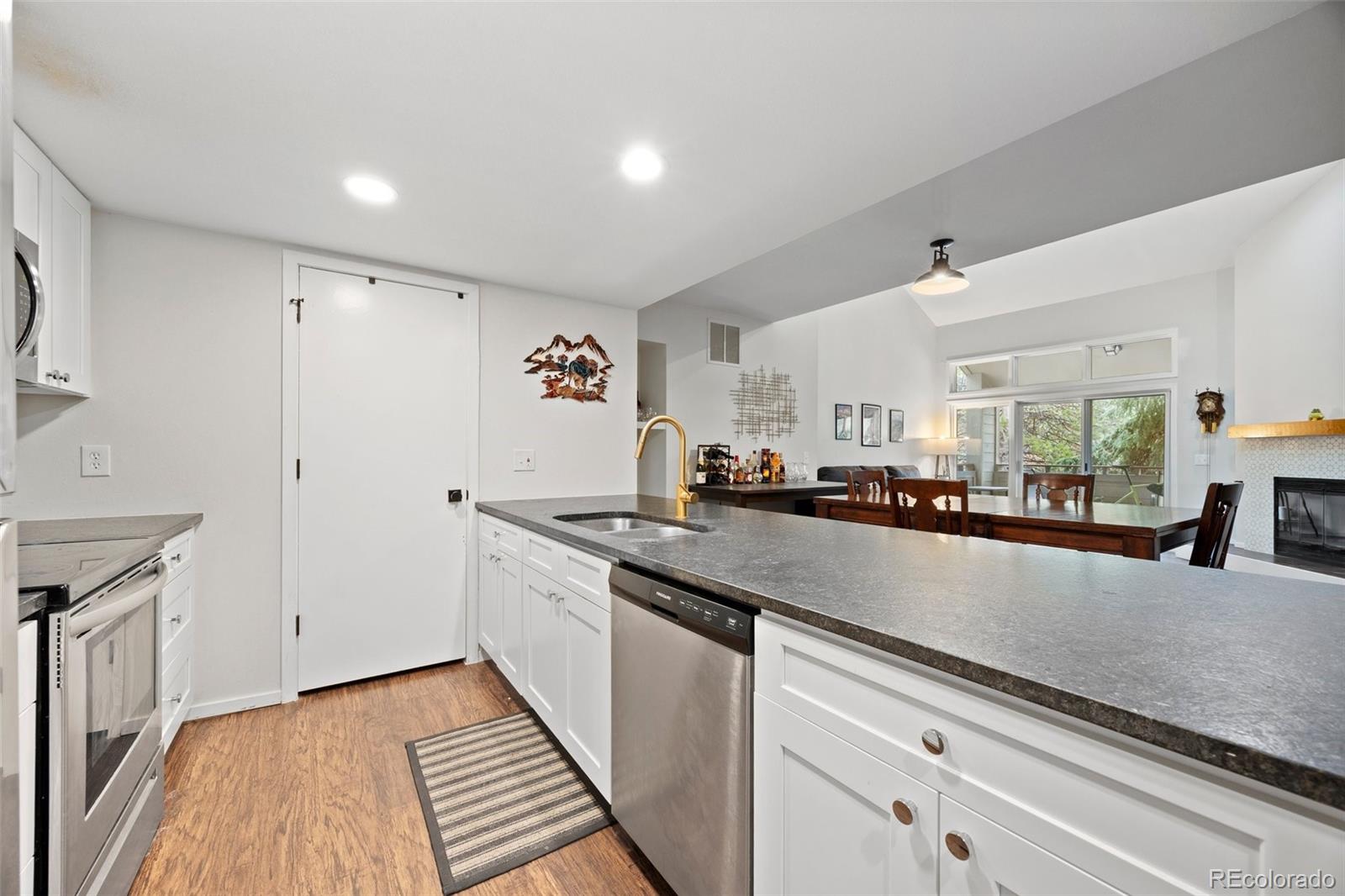 23551 Genesee Village Road, Unit H Golden, CO 80401 - Photo 14 of 40 a kitchen with granite countertop a sink and cabinets