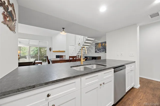 a kitchen with granite countertop white cabinets and white appliances