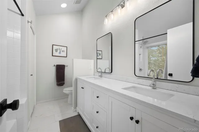a bathroom with a double vanity sink mirror and