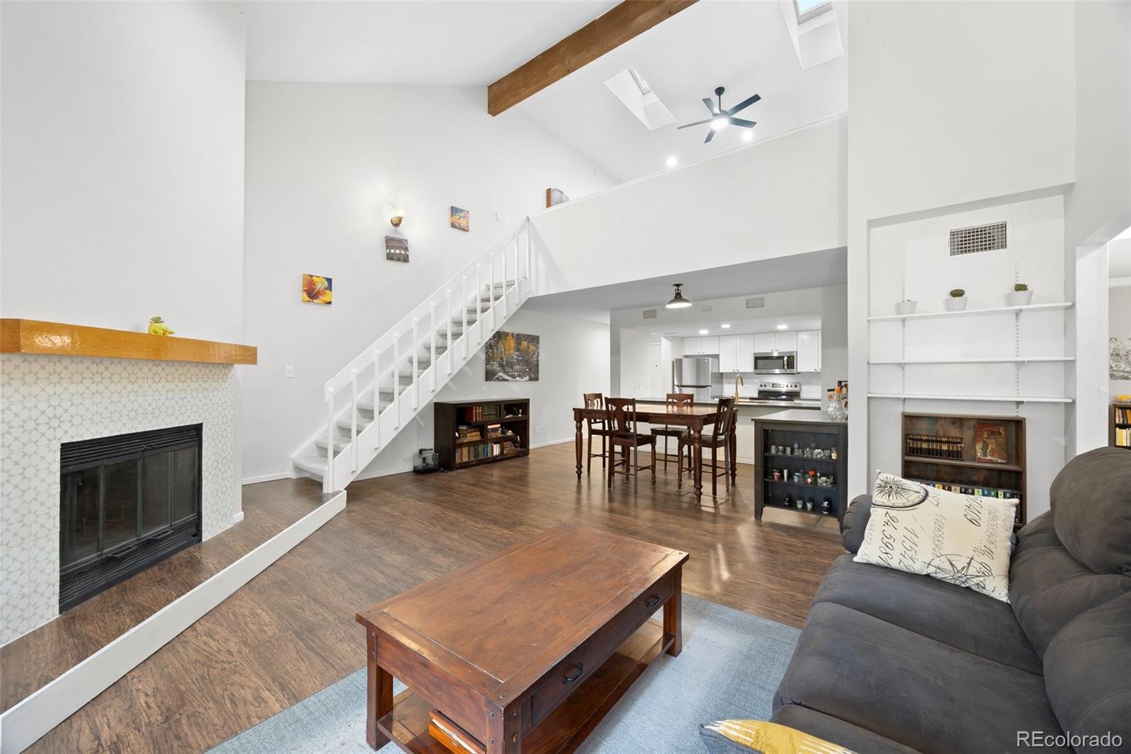 23551 Genesee Village Road, Unit H Golden, CO 80401 - Photo 2 of 40 a living room with furniture a fireplace and a ceiling fan