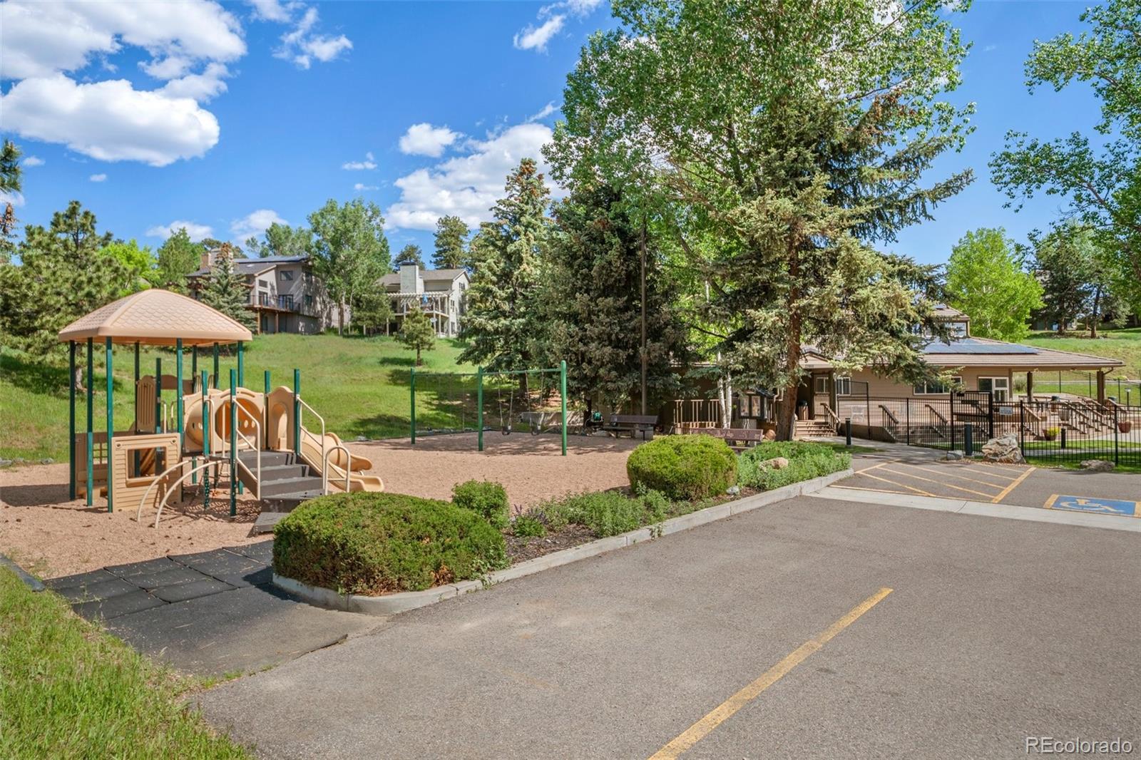 23551 Genesee Village Road, Unit H Golden, CO 80401 - Photo 30 of 40 a view of a patio with a table and chairs under an umbrella