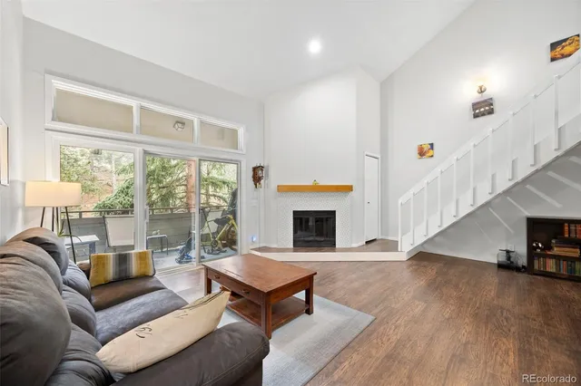 a living room with furniture a fireplace and a large window
