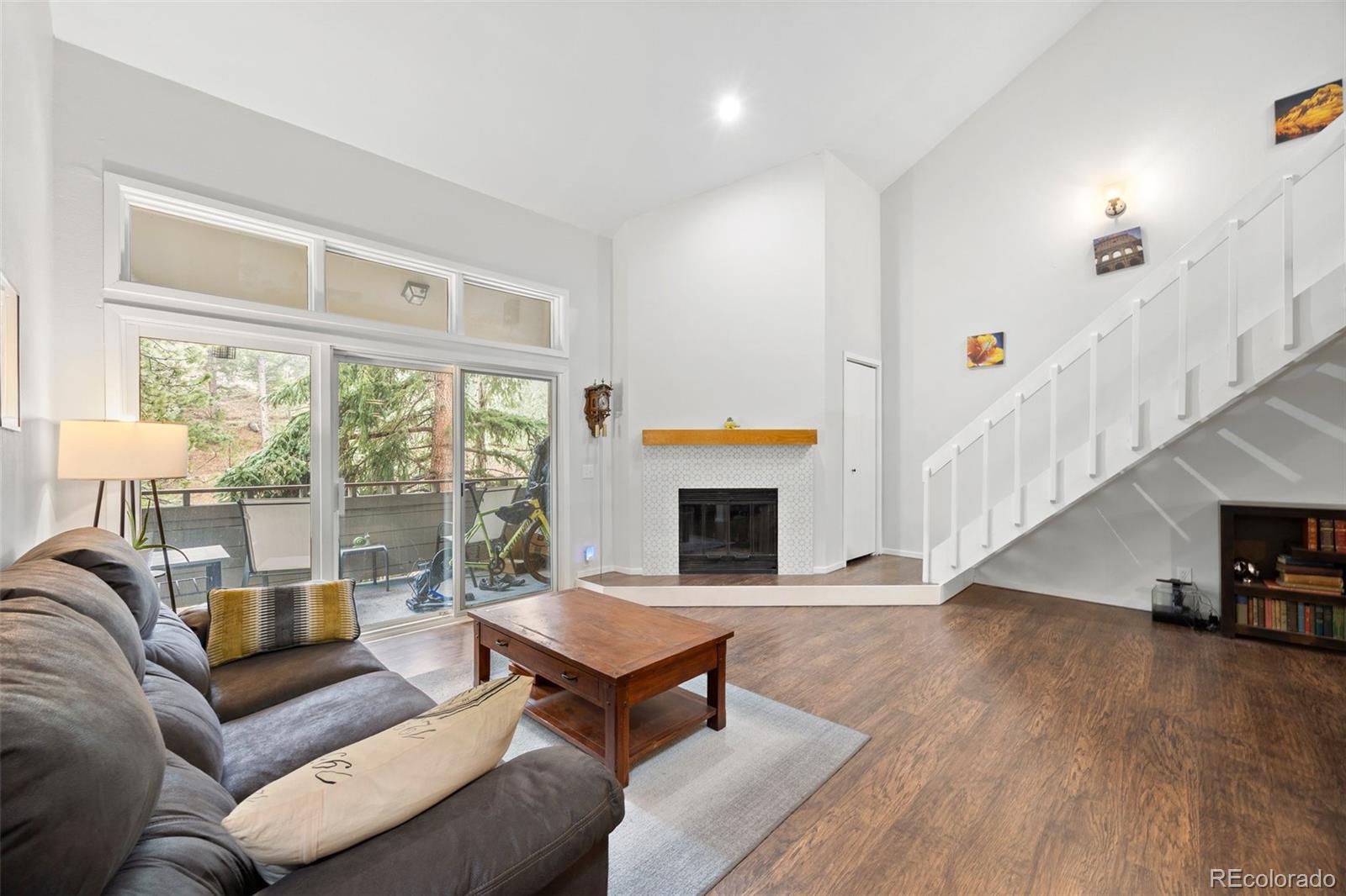 23551 Genesee Village Road, Unit H Golden, CO 80401 - Photo 7 of 40 a living room with furniture a fireplace and a large window