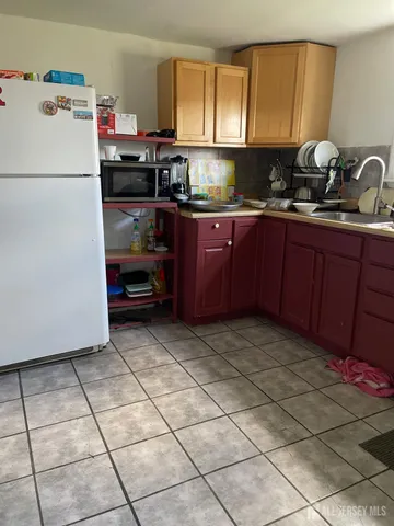 a kitchen with a refrigerator a stove a sink and cabinets
