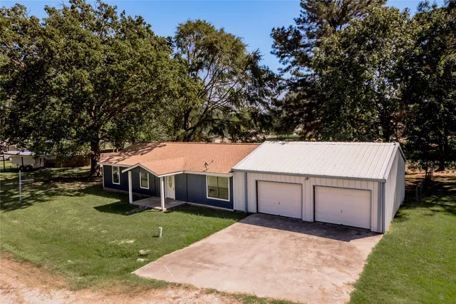 a aerial view of a house with a yard garage and outdoor seating