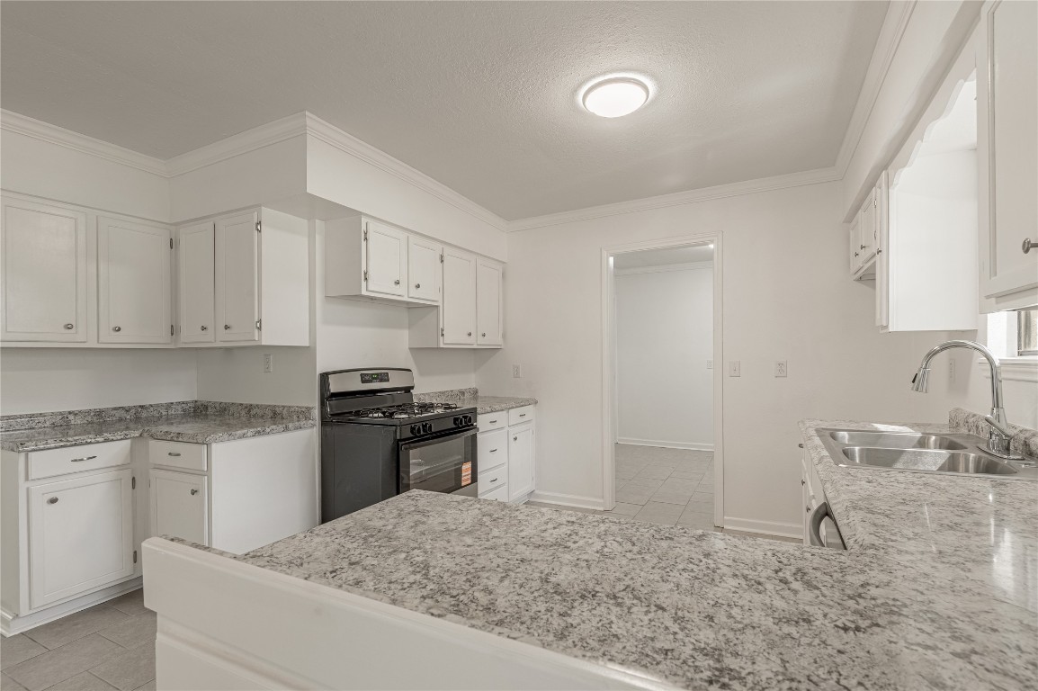 169 Sunset Drive Trinity, TX 75862 - Photo 11 of 36 a kitchen with granite countertop a sink stove and refrigerator