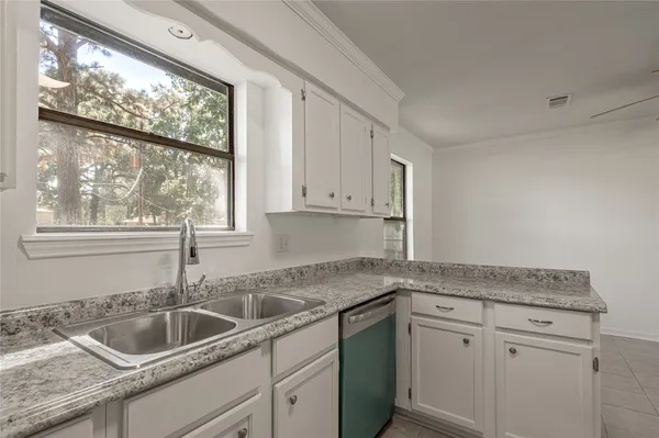 a kitchen with granite countertop white cabinets and a sink