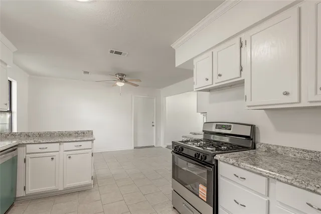 a kitchen with granite countertop white cabinets and white appliances