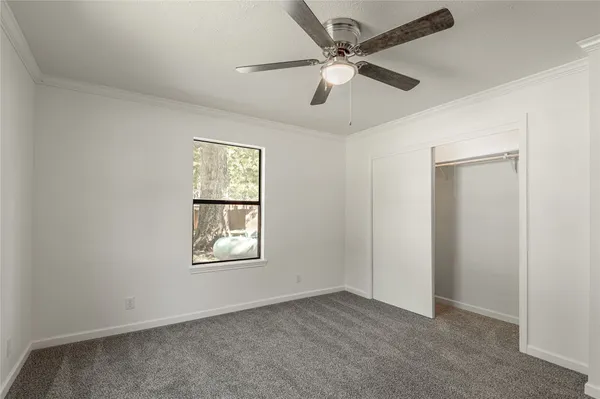 an empty room with windows and fan