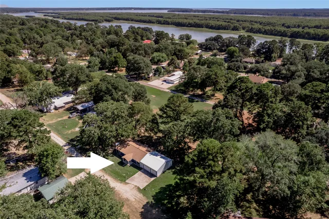 an aerial view of residential house with outdoor space and trees all around