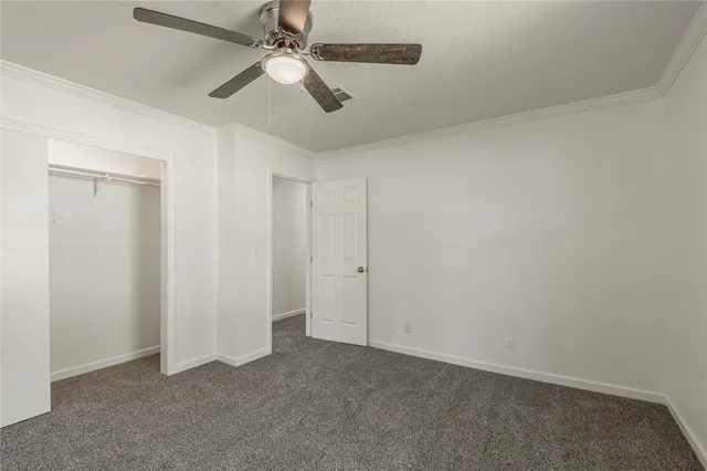 an empty room with chandelier fan