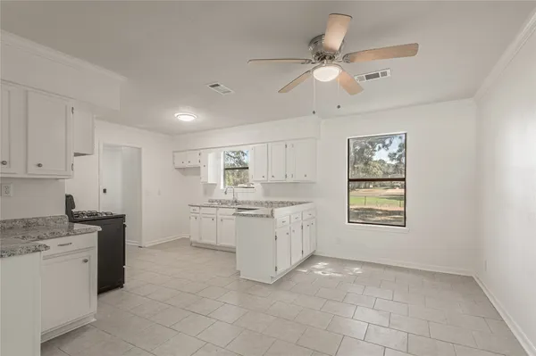 a kitchen with white cabinets and white appliances
