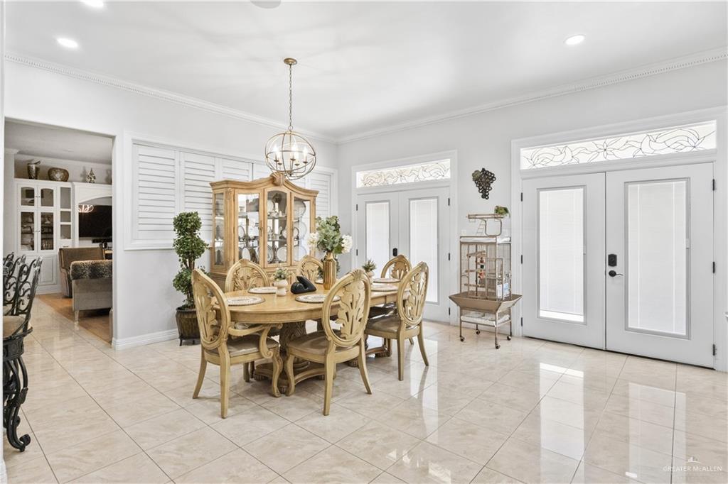 800 East Mile 3 Road Mission, TX 78573 - Photo 11 of 45 Dining area with french doors, light tile patterned flooring, ornamental molding, recessed lighting, and a chandelier