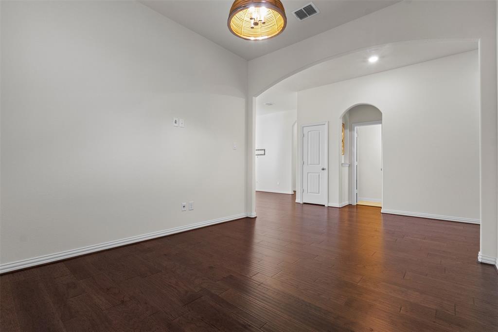 1740 Rio Costilla Road Fort Worth, TX 76131 - Photo 7 of 40 Hardwood-finish flooring throughout, white baseboards, arched doorways, and a drum-style ceiling light