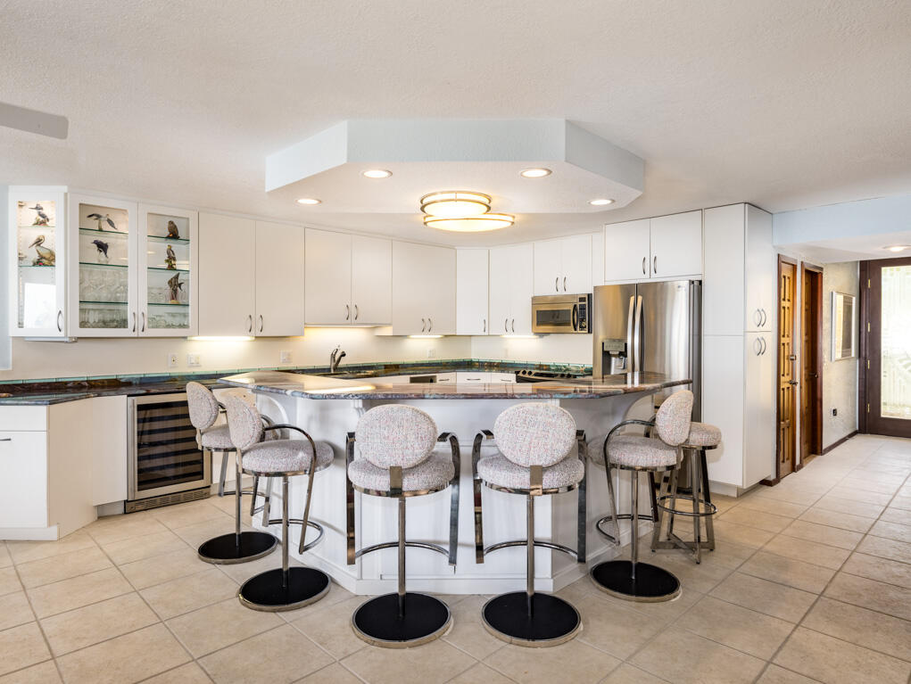 101 East Ocean Drive, Unit C304 Key Colony Beach, FL 33051 - Photo 10 of 39 a kitchen with a dining table chairs and a refrigerator
