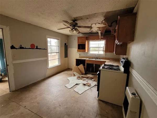 a kitchen with granite countertop a sink appliances and cabinets