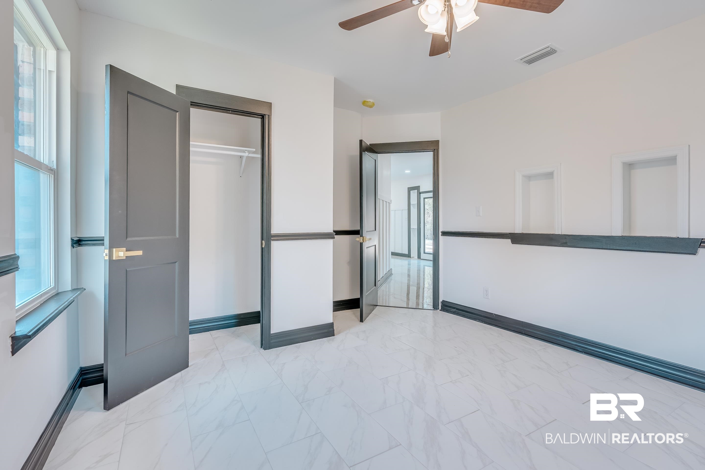 1190 Military Road Mount Vernon, AL 36560 - Photo 34 of 47 Unfurnished bedroom featuring light marble finish floors, a closet, and a ceiling fan