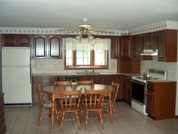 93 Crawford Road Rutland, MA 01543 - Photo 27 of 30 a kitchen with stainless steel appliances granite countertop a stove top oven a sink a dining table and chairs